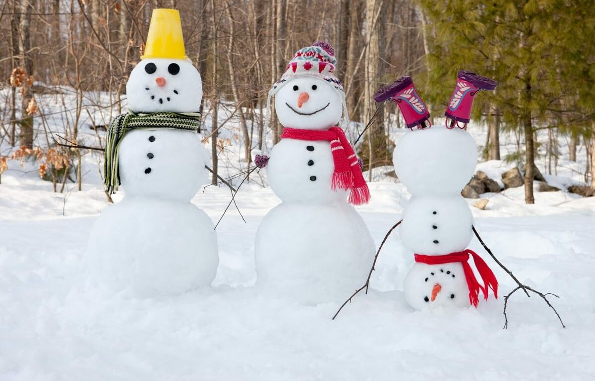 A family of snowmen, with the smallest one doing a headstand.