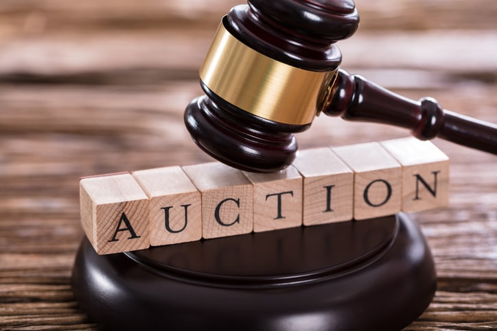 Closeup of a gavel striking on the word auction.